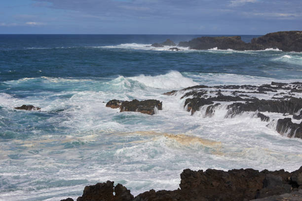 Ocean coastline with rocky cliffs and water foreground, Tenerife.
