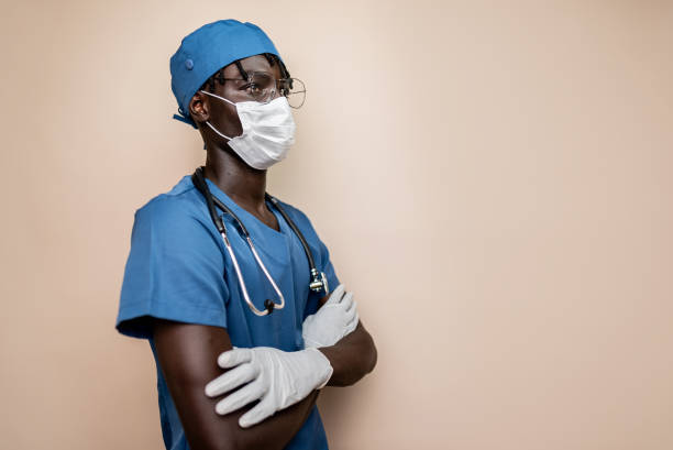 istock Young doctor contemplating looking away at beige background 2198718667