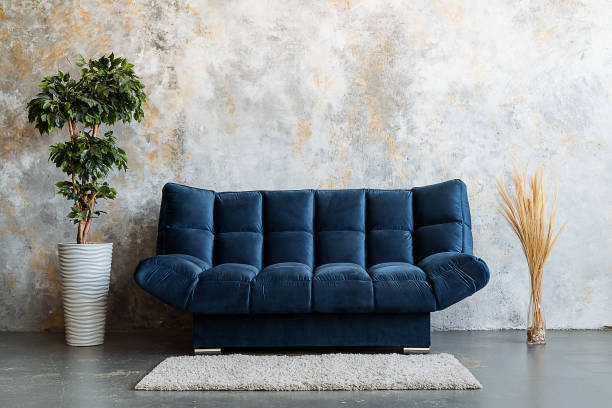 istock The living room features a stunning blue couch that is positioned next to a bright and lively potted plant, which together create a warm and inviting atmosphere for anyone who enters 2198719522