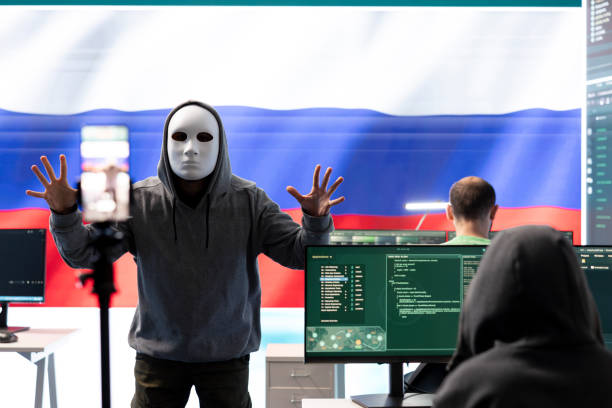 istock Anonymous person with mask asks for ransom in Russian governmental hacking room 2198719675