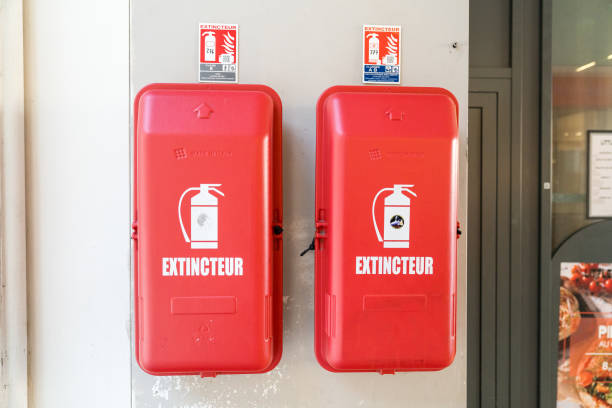 A bright red fire extinguisher is prominently hanging on a clean white wall, ensuring easy accessibility in case of emergencies