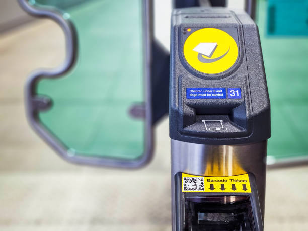 Modern electronic ticket barriers equipped with contactless payment touchpads at a modern railway station in southeast England.