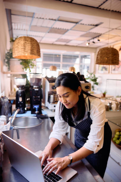 istock Cafe worker using laptop on counter top, busy working in small business 2198722921