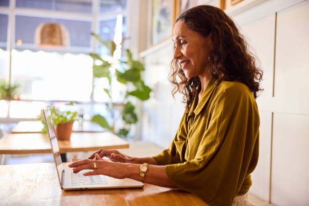 istock Mature woman using laptop, smiling, side view 2198723481