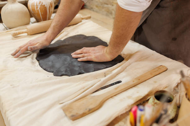 istock Partial view of master pressing black clay in pottery studio 2198724944