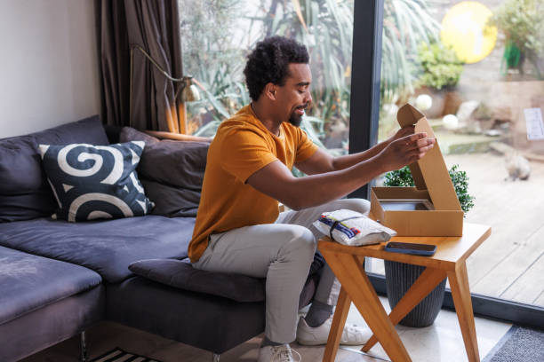 istock African American man unboxing a package from an online purchase 2198726053