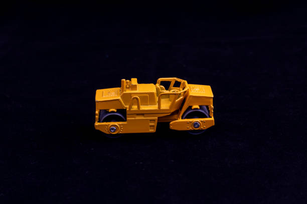 istock Yellow Toy Road Roller on Black Background 2198726195