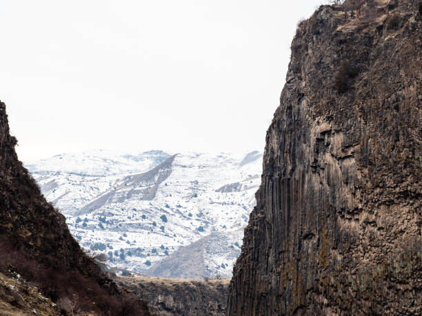 view snowy mountains through Garni Gorge from Symphony of the Stones site in Kotayk Province of Armenia on winter day