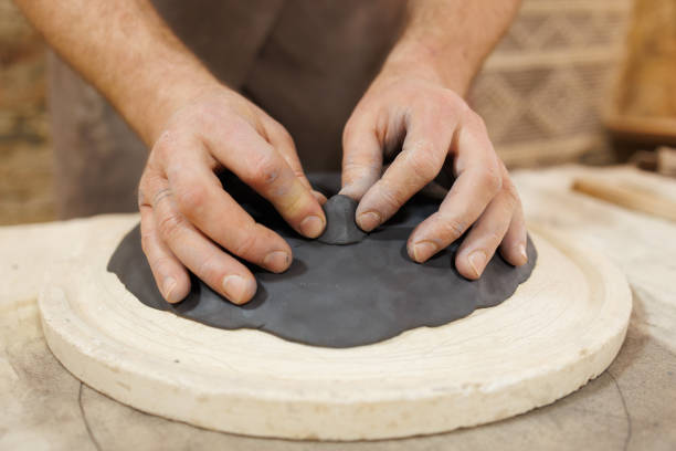 istock Close up of craftsman doing stand for clay plate in studio 2198727023