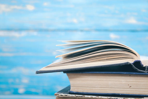 istock open book on books on blue wooden background 2198727147