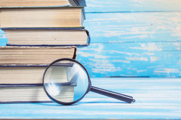 istock books and magnifier on a blue wooden table 2198727149