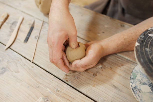 istock Top view of artisan forming clay near blurred tools in pottery studio 2198727923
