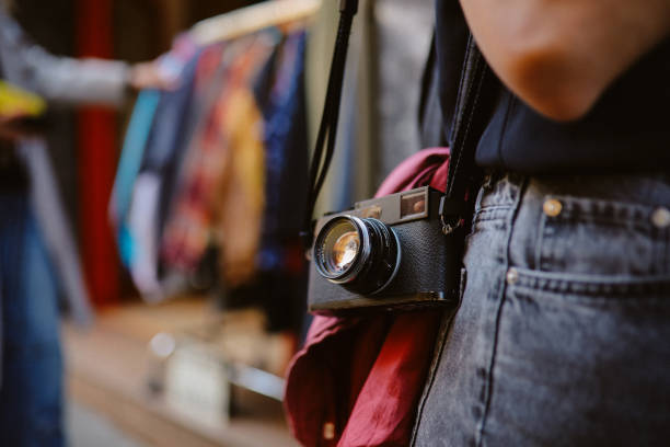 Tourist or a local woman using analog film camera to document her life. Vintage, retro concepts, slower pace of life.