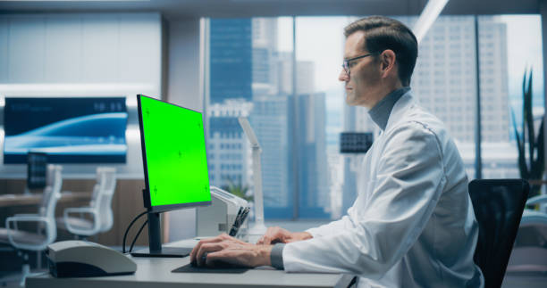 istock Male Scientist in a White Lab Coat Works on a Green Screen Computer in a Modern Medical Lab, Focusing on Research and Healthcare Analysis in a High-tech Hospital Environment 2198728786