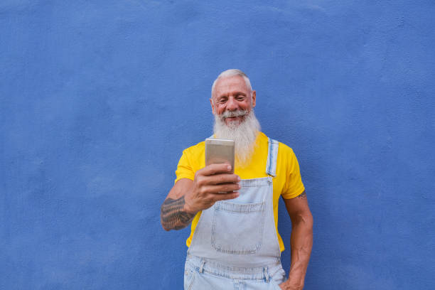 istock Happy hipster senior man using mobile phone app outdoor - Joyful elderly person and technology concept 2198730649