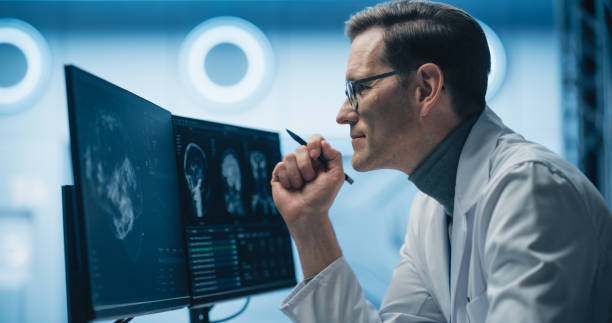 istock Portrait of Scientist Analyzing Brain Scans on Multiple Monitors in High-tech Laboratory. Advanced Medical Imaging Technology Displays Detailed Neurological Data for Advanced Research and Diagnosis 2198730706