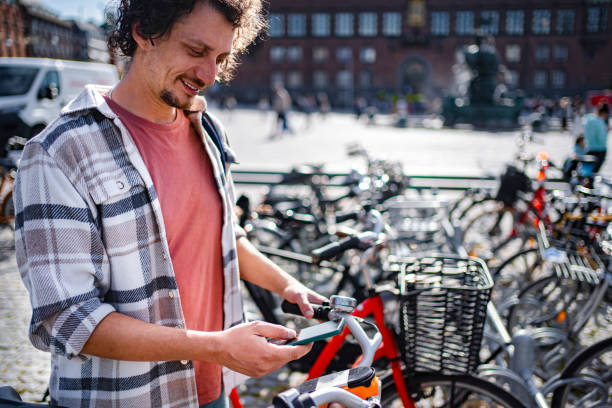istock Young man using smartphone while renting a bike in Copenhagen 2198731573