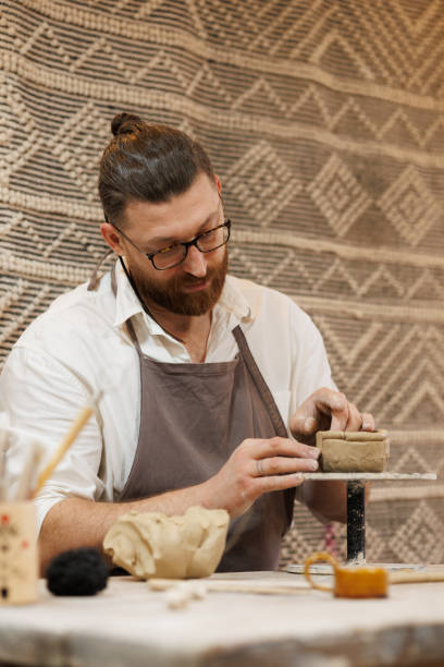 istock Artisan in apron shaping clay on wheel in workshop 2198737391