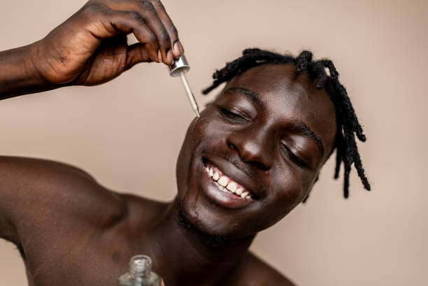 istock Young man doing skin care at beige background 2198739078