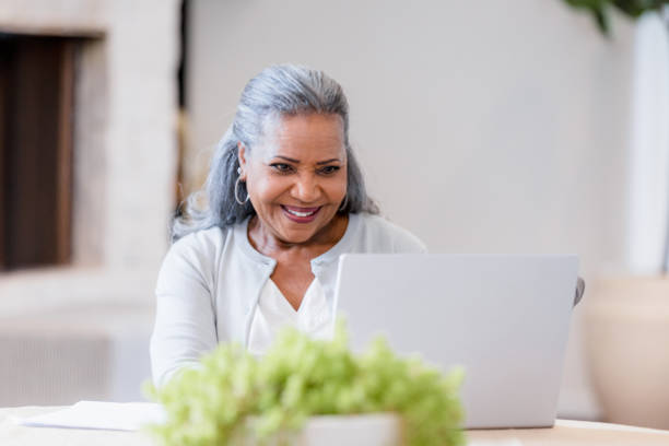 istock Smiling Senior Woman Using Laptop in Home Office 2198740646