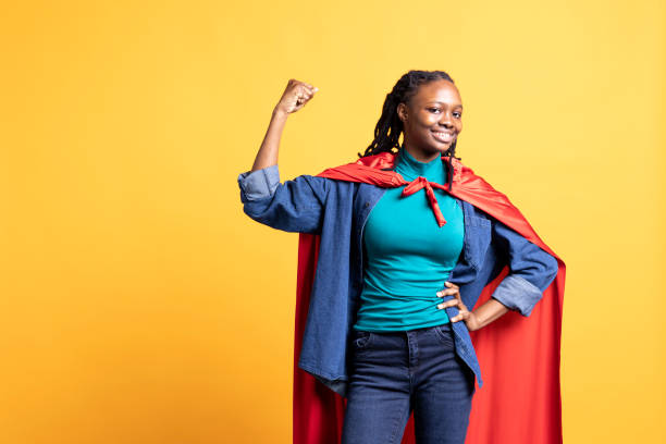 istock Girl flexing arm biceps, wearing superhero costume, studio background 2198740828