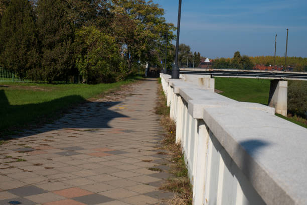 istock Scenic pedestrian walkway with white railing and greenery 2198743693