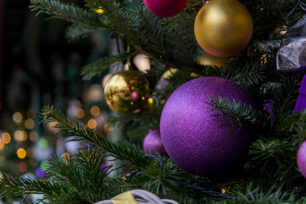 Ornamental decorations adorn an evergreen tree along a festive street