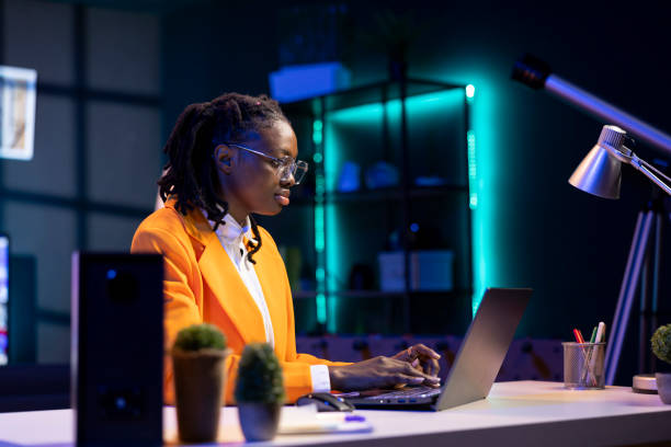 istock Woman wearing glasses using laptop in home office, checking emails 2198744514
