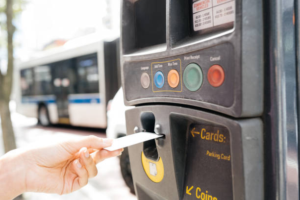 istock Latin woman using parking ticket machine to pay for parking 2198745680