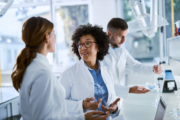 istock Chemist discussing with colleagues while working on research in a laboratory 2198746296