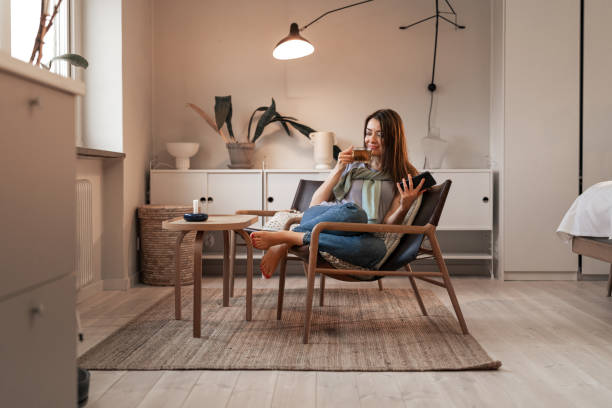 istock Young woman drinking tea in a cozy modern home interior 2198748441