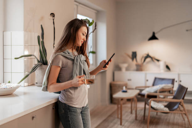 istock Young woman using smartphone in cozy home environment 2198748478