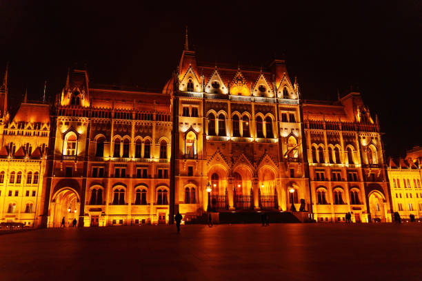 Budapest, Hungary - November 24, 2024: Hungarian Parliament Building glows warmly against a dark sky, showcasing its stunning architecture in Budapest at night.