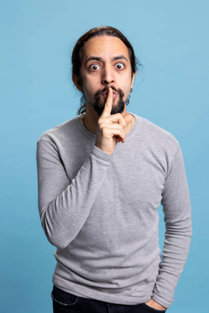 istock Middle eastern guy expressing hush and be quiet symbol with finger over lips, 2198749983