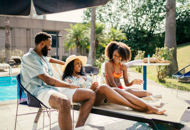 Family sunbathing by the hotel pool stock photo