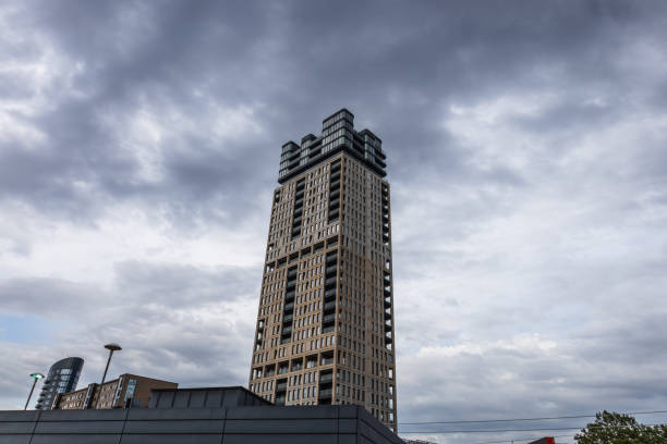 A striking modern high rise building stands tall against a cloudy sky in London, showcasing contemporary architecture and urban design