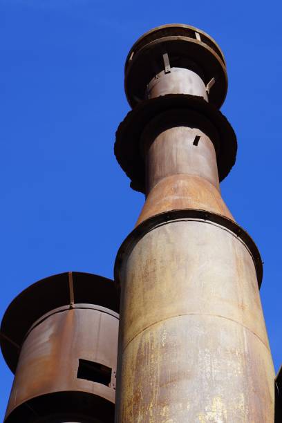 istock two old factory chimneys, rusted and rusted, against the blue sky 2198750443