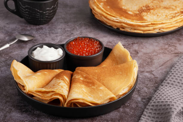 istock Delicious stack of golden pancakes served with cream and caviar on a rustic table 2198751002