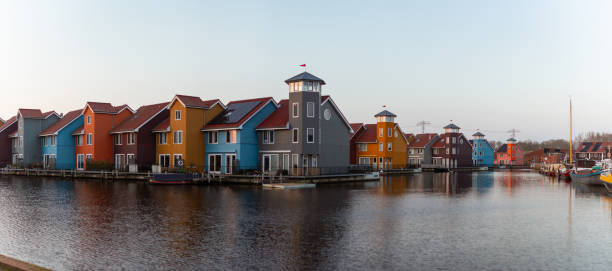istock Colorful Modern Waterfront Houses with Unique Tower Designs Reflecting on Tranquil Canal in Groningen Residential Area 2198751220
