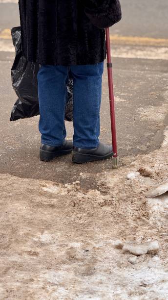 istock Taking a solitary stroll along a snowcovered street while using a cane for support 2198754648