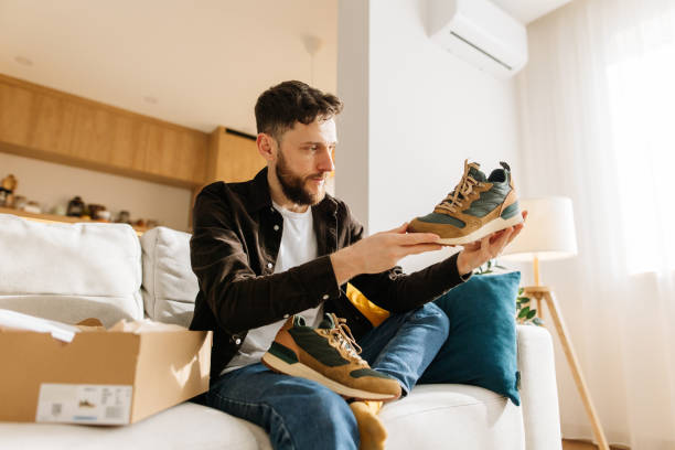 istock A man is satisfied examining his new sneakers ordered from an online store 2198755754