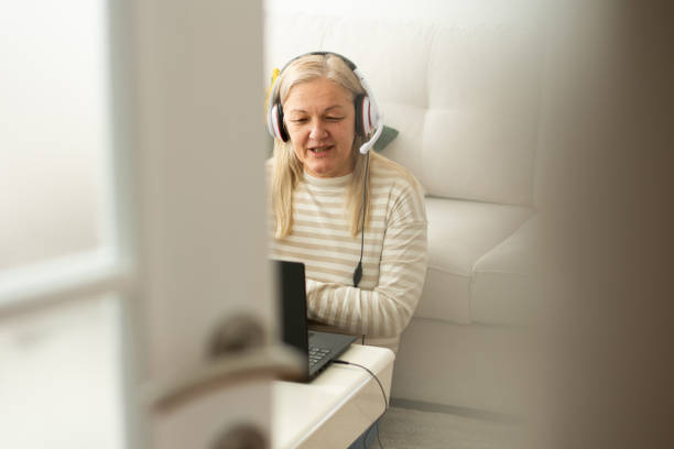 istock Mature woman learning class on laptop watching webinar at home 2198756323