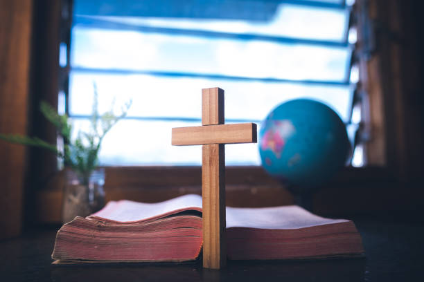 istock Cross standing whit bible at the window with light in morning. 2198756471