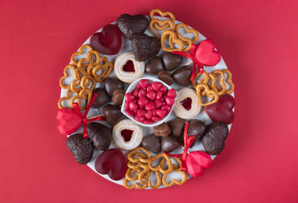 Plate of assorted heart sweets for Valentines Day on red background, Top view