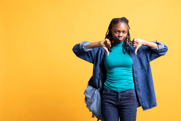 istock Upset woman showing thumbs down sign gesturing, studio background 2198757291