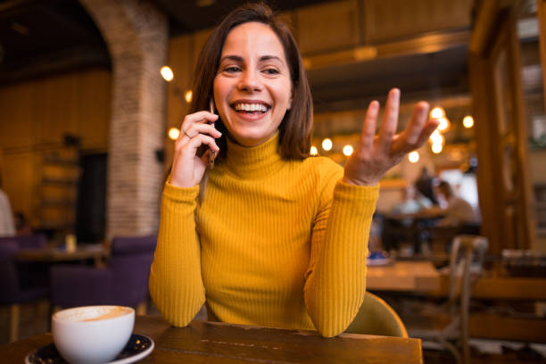 istock A young woman is talking on a smartphone in a cafe 2198758618