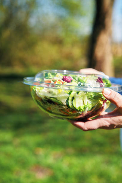 istock Eating Mixed Salad Bowl Packed in a Plastic Box Outside 2198760833