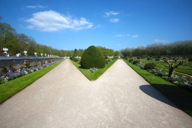 Symmetrical garden pathways leading to a central fountain, surrounded by well-maintained greenery.