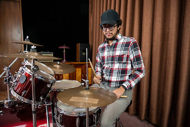 istock Drummer Playing Red Drum Set in Rehearsal Room 2198761518