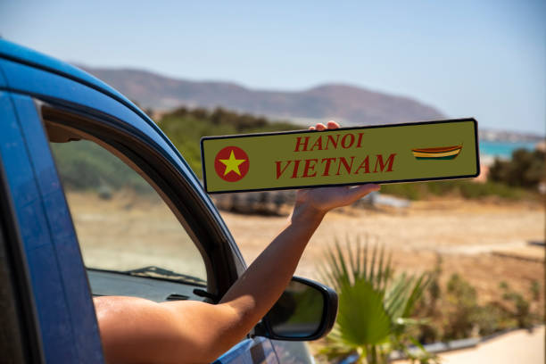 Man holding car license plate for Hanoi, Vietnam. Showing registration advertising traveling concept out car window